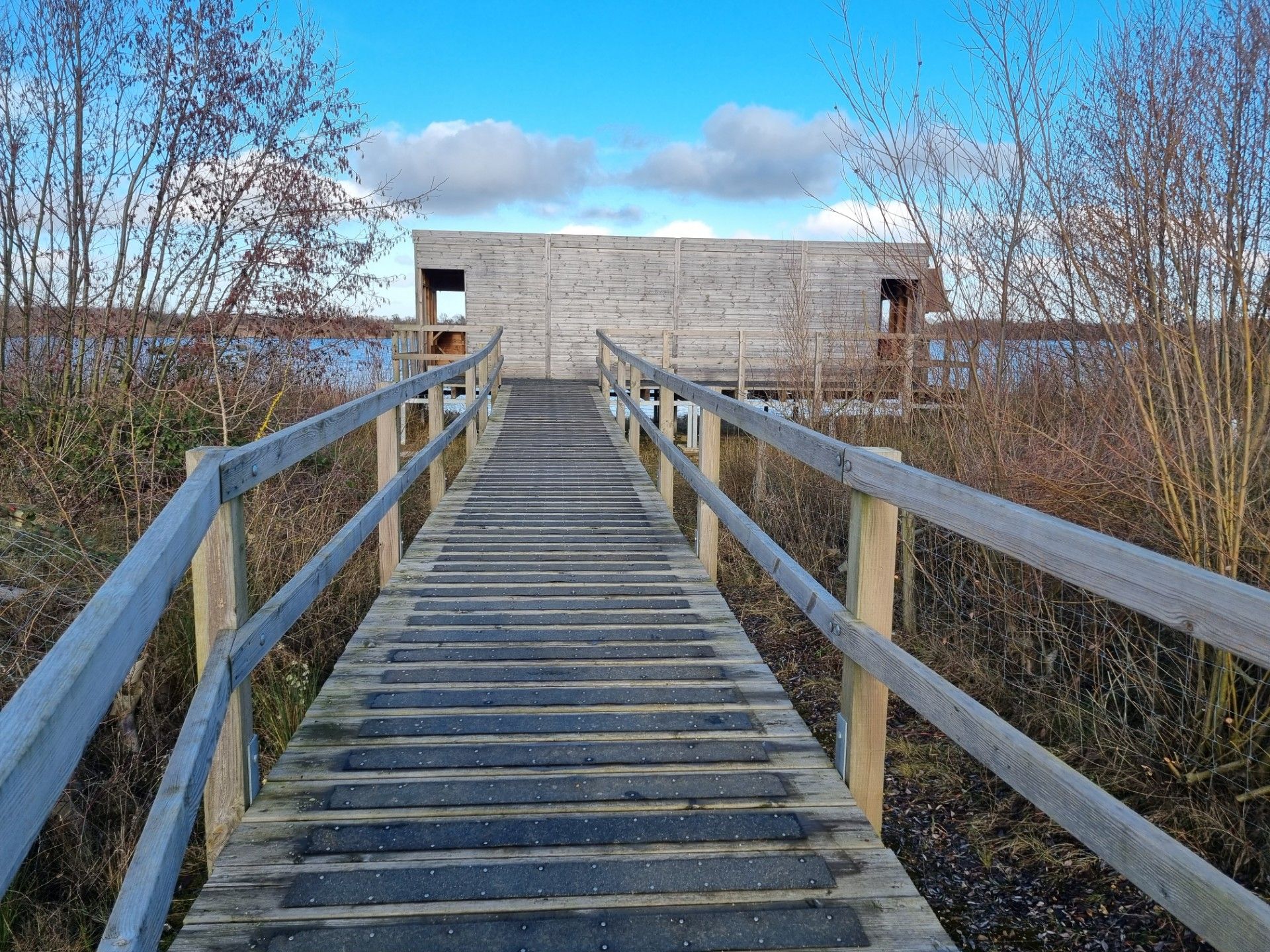 Picture of a wooden slatted bridge leading to a bird watching hide 